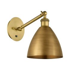 an antique brass wall light with a metal cone shade on the top and one arm