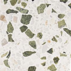 a white and green tile with small rocks on it