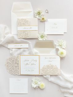 the wedding stationery is laid out with white flowers