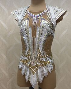 a mannequin wearing a white and gold costume with lots of sequins