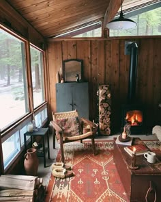 a living room filled with furniture and a fire place next to a wooden wall covered in wood