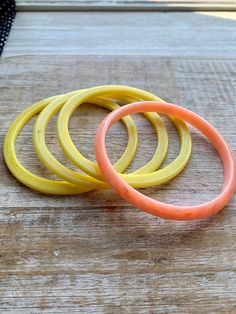 Acrylic bangle bracelet set of three yellow color and one salmon/coral colored bangle. Bangle hole measures 2 5/8 inches across diameter. Find more vintage jewelry on www.rollinrockabilly.com! Affordable Adjustable Yellow Bangle, Adjustable Yellow Round Bangle, Adjustable Stackable Yellow Jewelry, Yellow Adjustable Stackable Bracelets, Adjustable Yellow Stackable Bracelets, Adjustable Stackable Yellow Bracelets, Yellow Bangles, Acrylic Bangles, Ice Cream Shoes