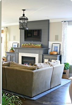 a living room filled with furniture and a fire place under a tv mounted above a fireplace