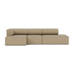 a beige sectional couch sitting on top of a white floor