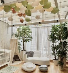 a living room filled with white furniture and lots of balloons hanging from the ceiling above