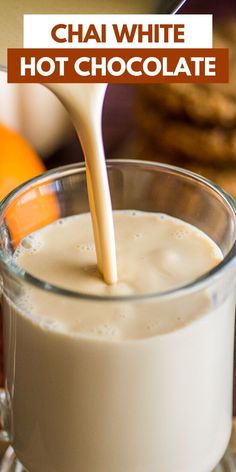 a person pouring milk into a glass mug with cookies in the background and text overlay reading chai white hot chocolate