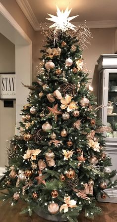 a decorated christmas tree with gold and silver ornaments in a living room or dining room