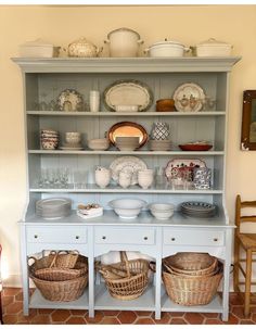 a china cabinet with baskets and dishes on it