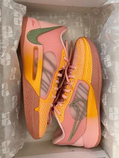 a pair of pink and yellow sneakers in a box