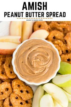 an apple and peanut butter spread is on a platter with pretzels, apples, and other snacks