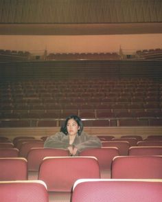 a woman is sitting in an empty auditorium