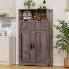 a wooden cabinet in the middle of a room with plants and food on top of it