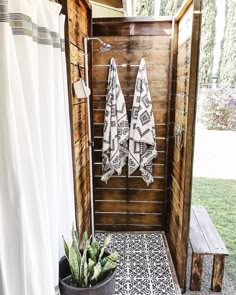 two white towels hanging on a wooden wall next to a potted succulent