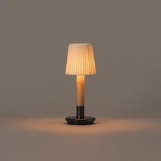 a table lamp with a white shade on it's base and a black stand