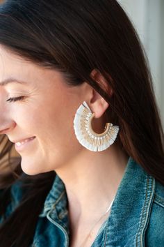 The Allison Rattan Fan Hoops are a delightful pair of earrings that embody the essence of a tropical vacation with a bohemian twist. Crafted with intricately woven rattan, these hoop earrings exude a sense of natural elegance. The unique fan-shaped design adds a touch of whimsy to the accessory, making them perfect for those seeking a playful and carefree style. Available in four stunning color options, these earrings allow you to express your personal taste and effortlessly enhance any outfit w Bohemian Hoop Earrings For Beach In Spring, Unique Adjustable Hoop Earrings For The Beach, Bohemian Woven Earrings For Beach, Chic Woven Earrings For Beach, Chic Woven Beach Earrings, Rattan Fan, Carefree Style, Bohemian Twist, Woven Rattan