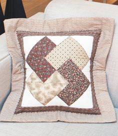 a white couch with a patchwork pillow on it