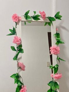 a mirror decorated with pink flowers and green leaves