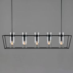 five light fixtures hanging from a black metal fixture with four bulbs on each end and one bulb in the middle