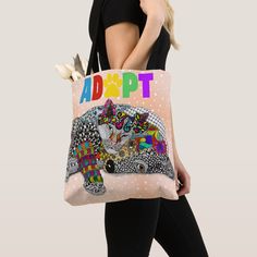 a woman carrying a tote bag with an image of a cat and flowers on it