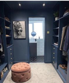 a walk in closet with blue walls and shelves