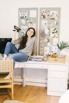 a woman sitting on top of a white desk