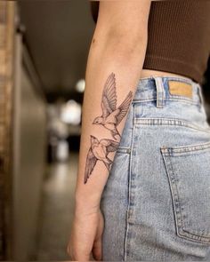 a woman's arm with a bird tattoo on the left side of her body