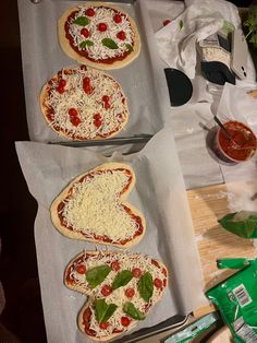 three uncooked pizzas sitting on top of baking sheets