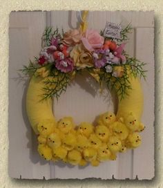 a yellow wreath decorated with flowers and peep holes