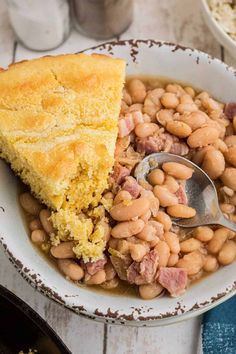 a white bowl filled with beans and cornbread