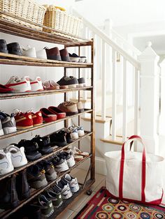 there are many pairs of shoes on the shelves in this room and one bag is next to it