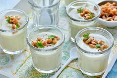 four glasses filled with food on top of a tray