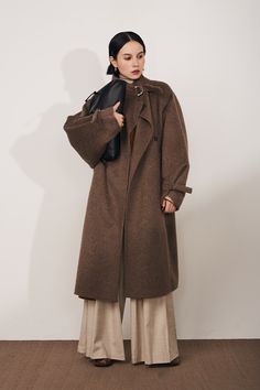 Luxe Stand Collar Coat: Winter's Must-Have Chic Crafted from premium first-cut Merino wool blended with a hint of rabbit hair for softness, this coat redefines winter luxury. Its classic trench sleeve tabs for adjustable length, complementing its loose A-line silhouette and dropped shoulder sleeves. Perfect for layerin Classic Brown Fur Coat For Work, Wool Fur Coat For Cold Weather In Fall, Fall Wool Fur Coat With Faux Fur Lining, Classic Fur Coat For Work In Fall, Brown Long Fur Coat For Work, Lambswool Outerwear With Faux Fur Lining For Fall, Fall Wool Fur Coat For Workwear, Fall Wool Outerwear With Faux Fur Lining, Brown Lambswool Outerwear For Fall