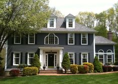 a large blue house with white trim and windows