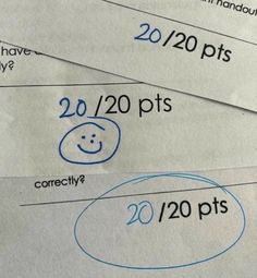 some paper with numbers written on them and smiley faces drawn on the top one in blue