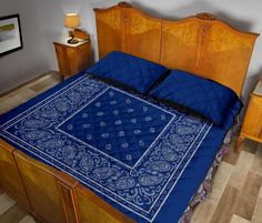 a bed with a blue comforter on top of it next to two nightstands