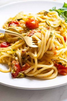 a white plate topped with pasta and vegetables