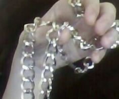 a person holding some kind of chain with their hands on the other side of them