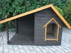 there is a dog house made out of wood and has a small window on the roof