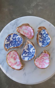 four pieces of porcelain with pink and blue designs on them sitting on a white plate