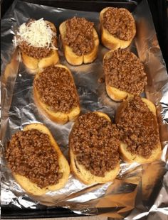 several sloppy joes are sitting on top of tin foil and ready to be baked