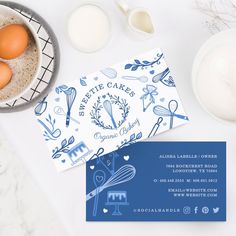 an image of some food and business cards on a white table with utensils