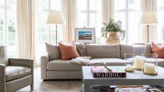 a living room with two couches and a coffee table in front of large windows