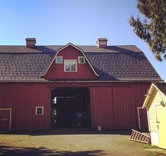 a large red barn with a black roof