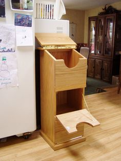 a kitchen with a refrigerator and wooden cabinet in it's center, next to a wood floor