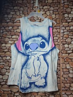 a tank top with an image of stitching stitchs on it, hanging against a stone wall