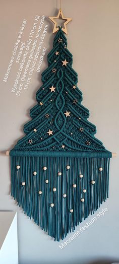 a crocheted christmas tree with stars hanging from it's sides and fringes