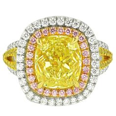 This one of a kind diamond ring, designed by Diana M. Jewels combines three natural colored diamonds, Fancy Pink, Fancy Yellow and White diamonds. The center stone is 5.02 Carats Fancy Yellow Cushion Cut Diamond, SI1 in Clarity, accompanied by EGL Certificate, surrounded by natural fancy pink, fancy yellow and white diamonds totaling 2.00 carats. Yellow Diamond Ring With Pave Setting For Anniversary, Dazzling Brilliant Cut Yellow Diamond Ring, Dazzling Yellow Brilliant Cut Diamond Ring, Dazzling Yellow Diamond Ring With Accents, Luxury Yellow Diamond Ring, Dazzling Yellow Diamond Ring With Center Stone, Yellow Diamond Ring With Center Stone, Luxury Yellow Moissanite Diamond Ring, Fine Jewelry Yellow Diamond Ring With Center Stone