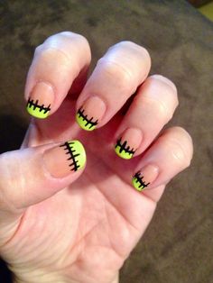 a person with yellow and black nails holding up their fingers to show the nail art