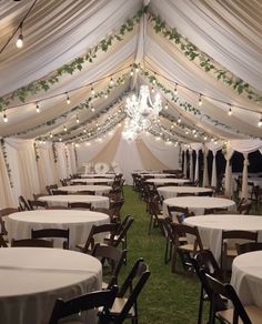 the inside of a tent with tables and chairs set up for a wedding or party