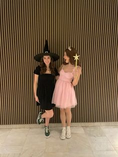 two girls dressed up as witches and one is holding a wand while the other holds a star